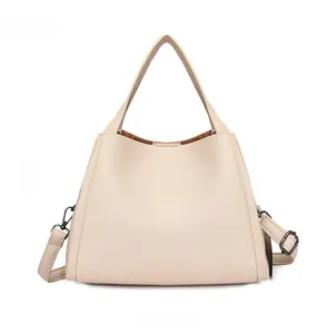 Detail view of the beige bucket bag back with detachable strap and gunmetal hardware
