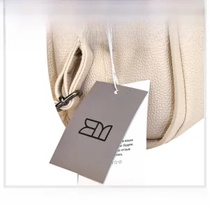 Detail of cream lychee leather handbag showing silver buckle and brand hangtag