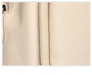Detailed macro view of cream litchi grain leather and high-quality piping craftsmanship