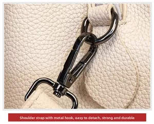 Detail of durable gunmetal hook and D-ring on minimalist beige pebbled leather bucket bag