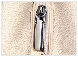 Detail of gunmetal zipper puller and pebble leather texture on casual bucket bag