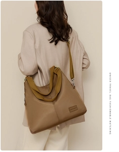 Close-up of khaki waterproof nylon tote bag with wide shoulder strap on a model