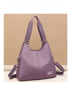 Detailed view of purple waterproof nylon tote bag with wide strap and silver metal rings