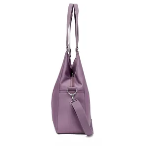 Detail view of purple waterproof nylon tote bag with adjustable strap and silver hardware