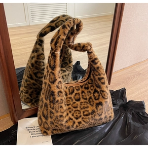Détail du sac hobo en fausse fourrure léopard se reflétant dans un miroir en bois