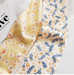 Détail d'un foulard en soie avec imprimé floral double face et texture lisse