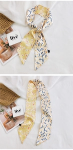 Détail d'un foulard Twilly double face avec motifs floraux en jaune et crème
