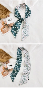 Détail d'un foulard étroit double face avec motifs floraux et pois sur tissu satiné