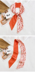 Détail d'un foulard en soie fine aux motifs géométriques orange chaud sur un sac en paille