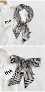 Détail d'une écharpe étroite à motif pied-de-poule noir et blanc en 100% polyester
