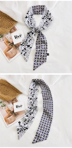 Détail d'un foulard en soie avec motifs paisley et carreaux noué sur un sac en paille