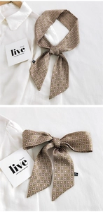 Détail macro d'un foulard étroit à motifs floraux sur un tissu blanc élégant