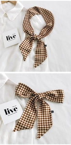 Gros plan d'un foulard en pied-de-poule marron et blanc montrant divers nœuds et styles
