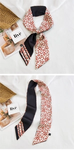 Détail macro du foulard twilly vintage français avec imprimé floral et motif rayé