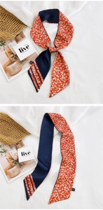 Détail d'un foulard en soie réversible à fleurs rouges et bleu marine noué en joli nœud