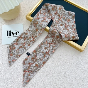 Détail d'une écharpe étroite grise avec motif paisley et texture douce élégante