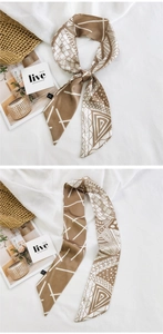 Détail d'un foulard géométrique en soie caramel et beige sur un fond en lin texturé