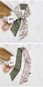 Détail d'un foulard étroit en soie double face avec motifs de cœur et fini satiné