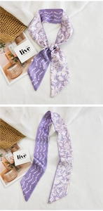 Vue détaillée du foulard twilly violet à motif cœurs posé sur un tissu blanc