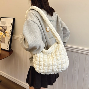 White quilted cloud shoulder bag with large capacity displayed on a model in soft light