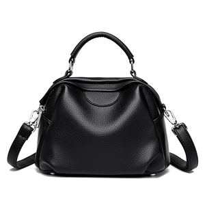 Classic black shell-shaped handbag in lychee grain leather with adjustable shoulder strap
