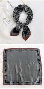 Detail of silk square scarf featuring black white houndstooth pattern and brown border