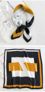Close-up of geometric square silk scarf with satin luster styled on a white shirt