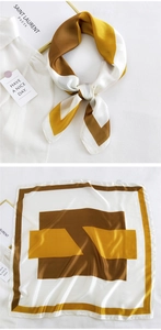 Detailed view of silk scarf with geometric blocks in brown and mustard yellow