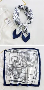 Detail of silk square scarf showing blue geometric spiral pattern and border texture