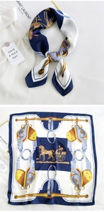 Detail of silk square scarf featuring equestrian patterns of horses and golden buckles