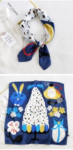 Detail of a navy blue silk scarf with cartoon rabbits and dots, showing tied and flat views