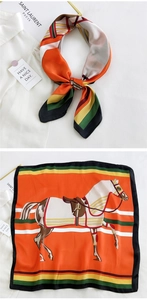 Close-up of orange silk square scarf with equestrian horse print and striped borders