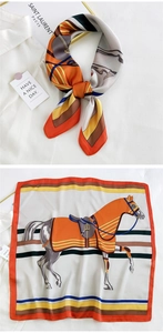 Detail of silk square scarf featuring a classic horse print with elegant orange borders