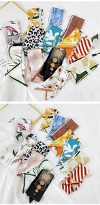 Multiple printed narrow silk scarves with floral and leopard patterns on white fabric