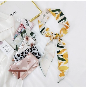 Detailed view of assorted silk-feel narrow scarves with floral and leopard patterns