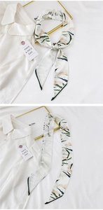 Detail of elegant floral long silk scarf with handwritten script on off-white fabric