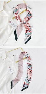 Detailed view of pink floral twilly scarf with blue patterns and smooth silk texture