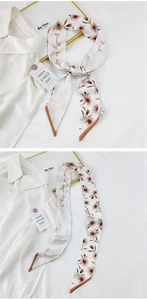 Detail of floral twilly scarf with pink flowers and calligraphy on silk-like fabric