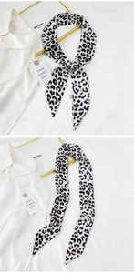 Detail of leopard print long skinny scarf showing fabric texture and laundry care label