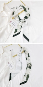 Detail of silk scarf with floral prints and handwritten phrases on smooth fabric