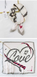 Detail of elegant silk square scarf featuring heart chains and Love script pattern