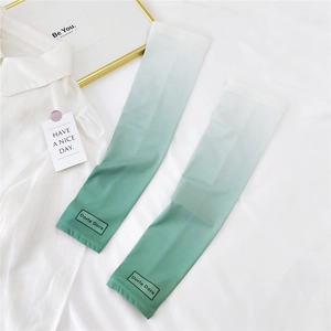 Detail of green and white gradient cooling ice silk sun protection sleeves on white bedding