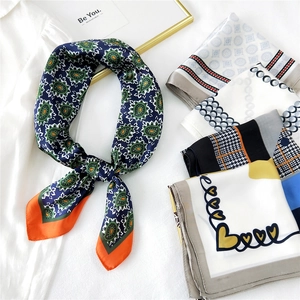 Navy paisley silk scarf with geometric patterns and orange border displayed on white fabric
