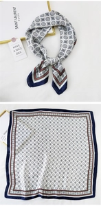 Detailed view of square silk scarf with geometric medal pattern and dark blue borders