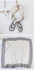 Detail view of square silk scarf with vintage badge patterns and geometric borders