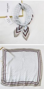 Detailed flat lay of silk square scarf featuring blue polka dots and geometric borders