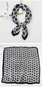 Detail view of square silk scarf with black and white paisley pattern and solid border