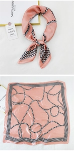 Detail of pink silk square scarf with geometric chain pattern and soft satin texture
