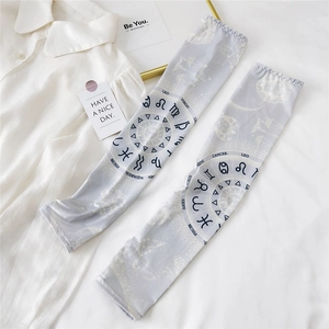 Close-up of light grey sun protection arm sleeves with celestial sun and zodiac pattern