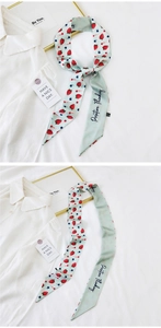 Detail of light green silk scarf with strawberry pattern and Positive Thinking print